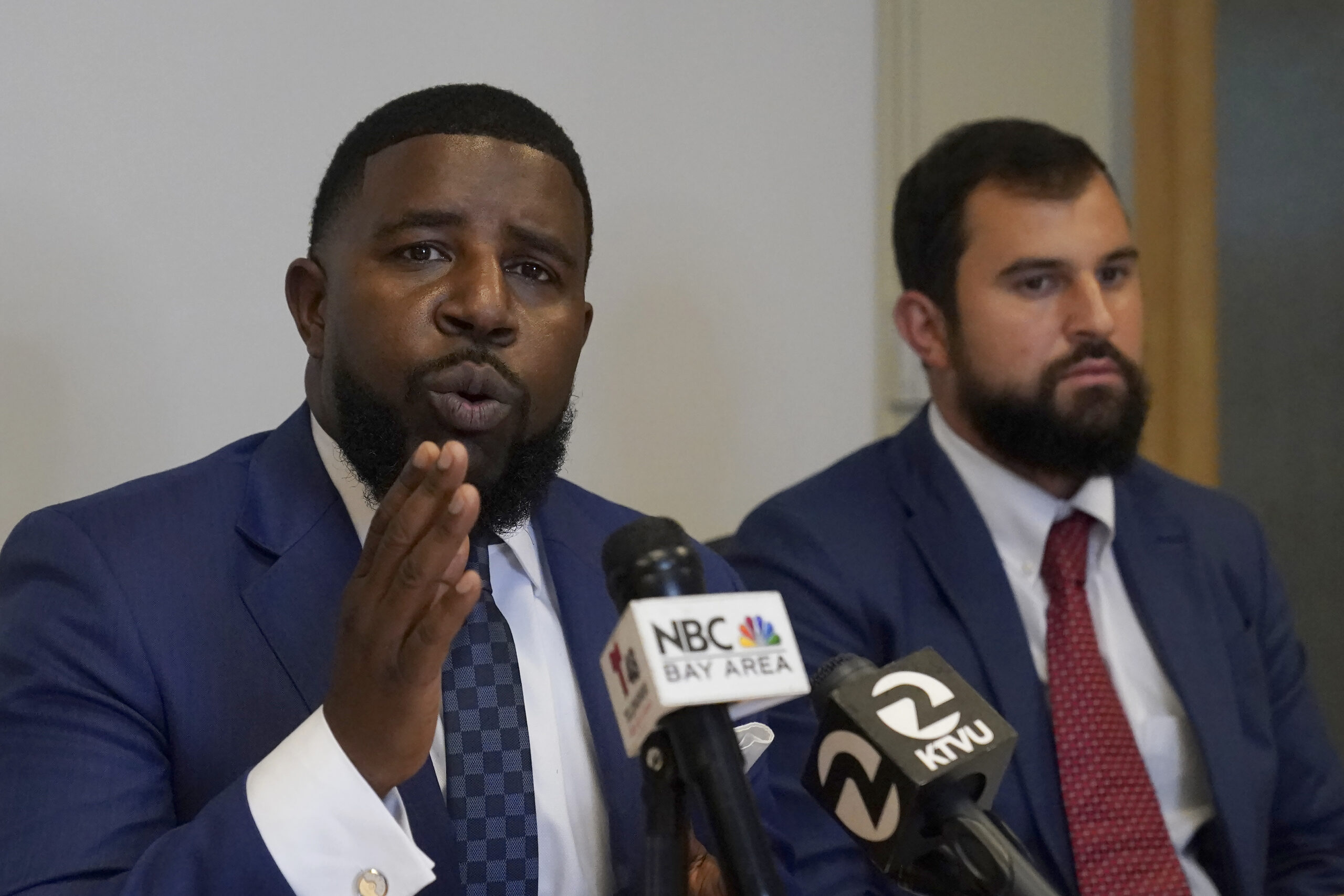 Attorneys Adanté Pointer, left, and Patrick Buelna, who represent a woman whose DNA from a sexual assault case was used by San Francisco police to arrest her in an unrelated property crime, speak during a news conference announcing their lawsuit against the city of San Francisco at their law office in Oakland, Calif., Monday, Sept. 12, 2022. (AP Photo/Jeff Chiu)