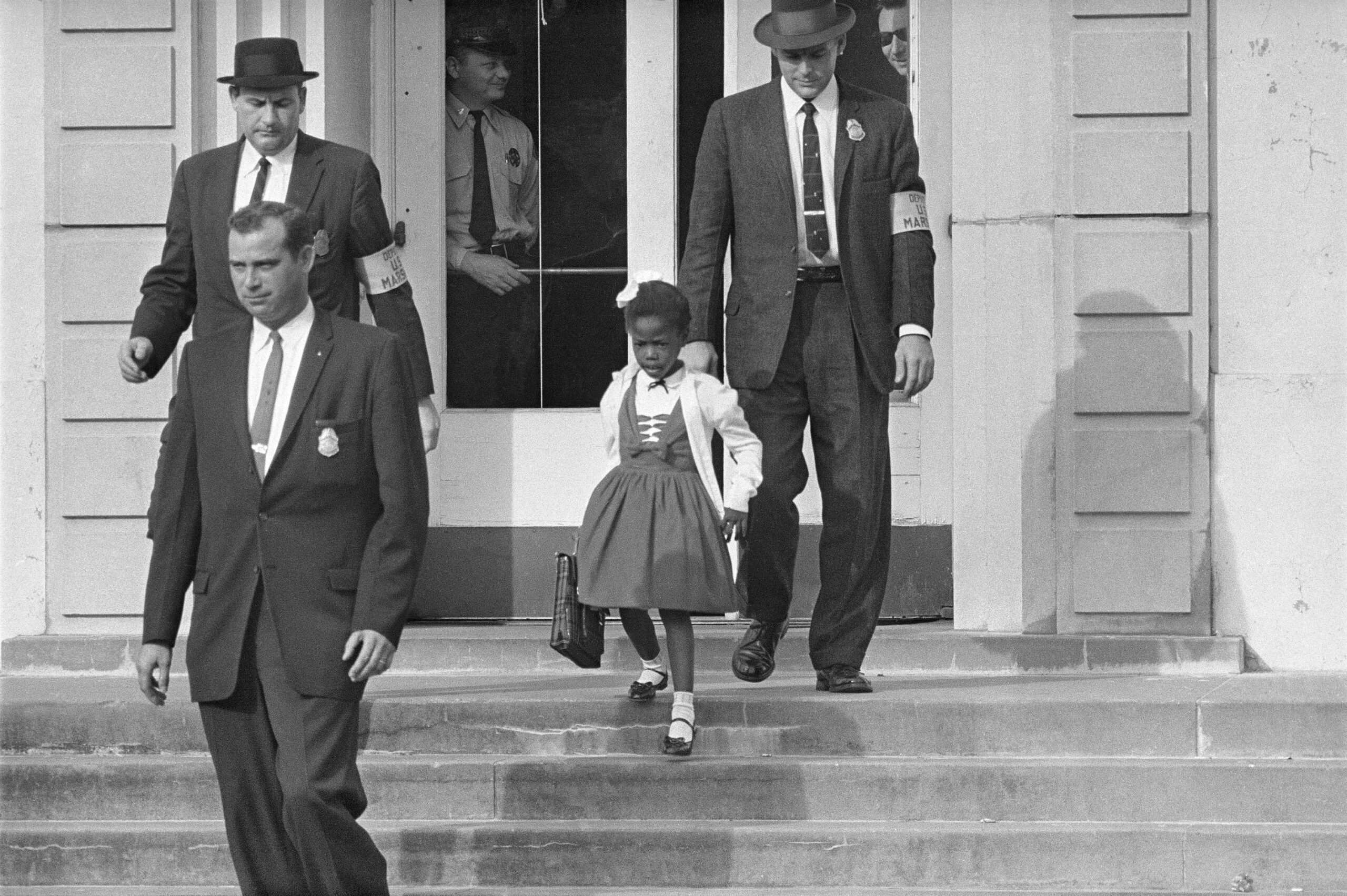FILE - U.S. Deputy Marshals escort 6-year-old Ruby Bridges from William Frantz Elementary School in New Orleans, in this file photo from November 14, 1960. Bridges has authored a picture book to explain that long-ago experience to the youngest readers. (AP Photo/File) /