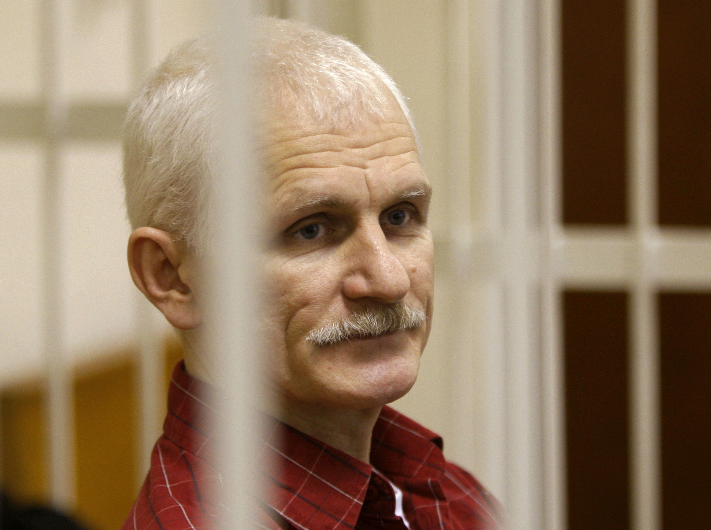 FILE - Ales Bialiatski, the head of Belarusian Vyasna rights group, stands in a defendants' cage during a court session in Minsk, Belarus, on Wednesday, Nov. 2, 2011. On Friday, Oct. 7, 2022 the Nobel Peace Prize was awarded to jailed Belarus rights activist Ales Bialiatski, the Russian group Memorial and the Ukrainian organization Center for Civil Liberties. (AP Photo/Sergei Grits, File)